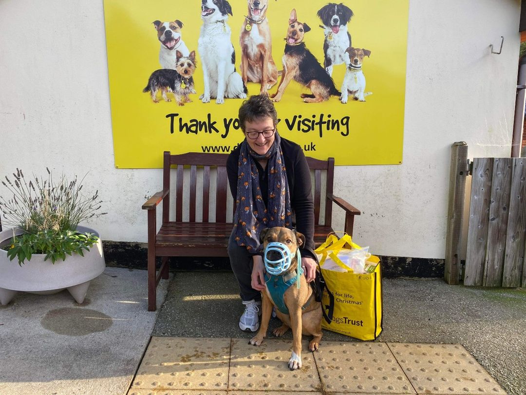 Rudi with his new owner Jo sitting together on a bench 