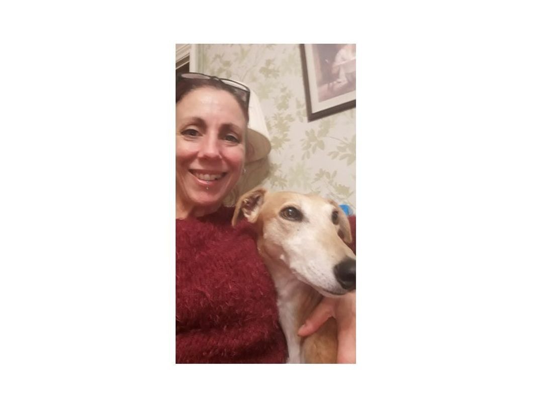 Sue and her lurcher Pearl smiling at the camera.