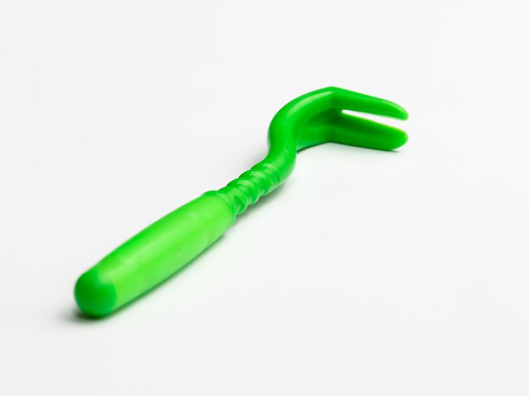 Image of a green tick remover tool.