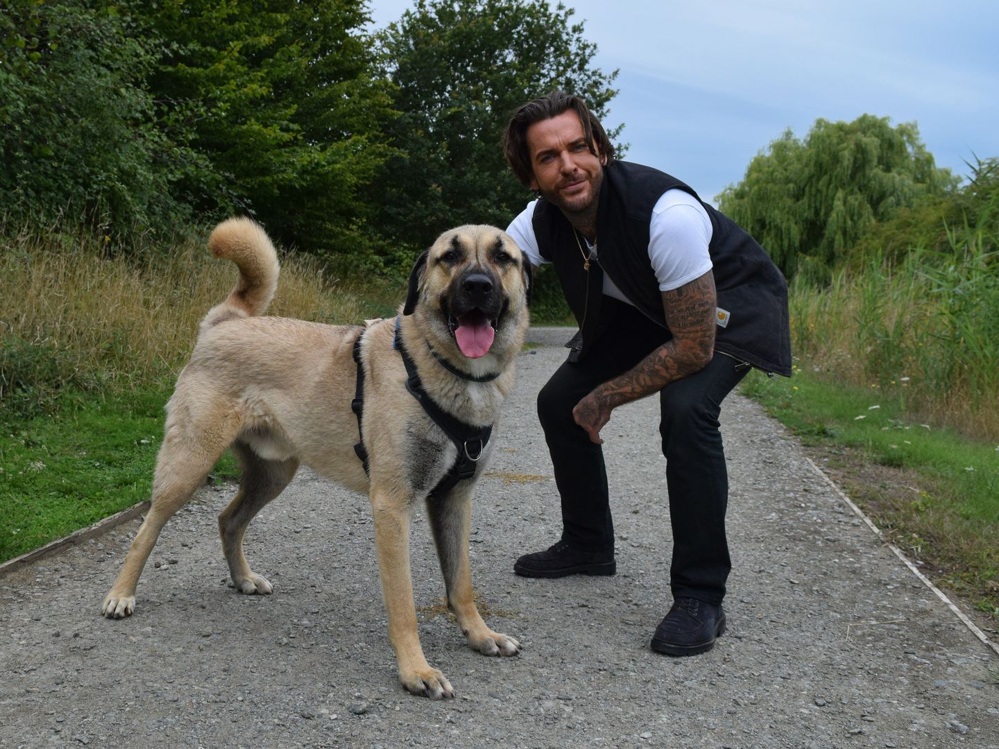 Pete Wicks sits next to Hank, a large dog who has spent a very long time in kennels.