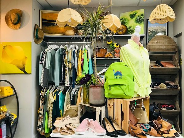 Image of the inside of a charity shop with bags, clothes and shoes.