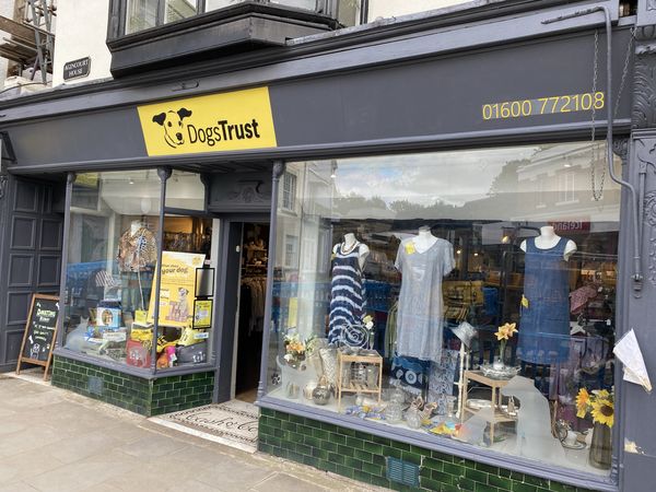 Outside Monmouth's charity shop with mannequins and bric a brac displays in the windows