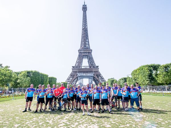 a big group of people standing in front of the Eiffel Tower