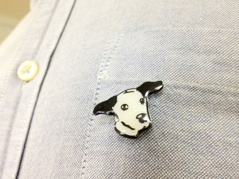 Lapel pin being worn on a pale blue shirt