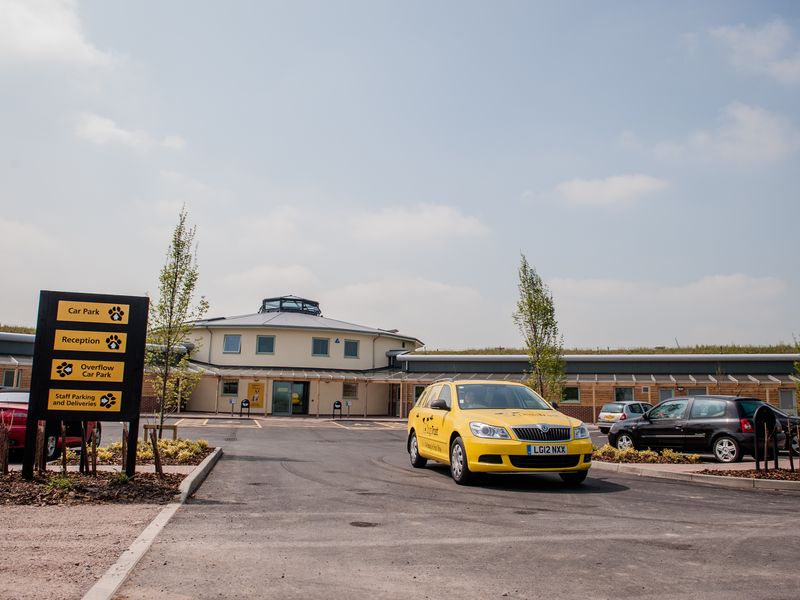 Outside view of Dogs Trust Loughborough's rehoming centre, featuring signs and a yellow dogs trust branded car.