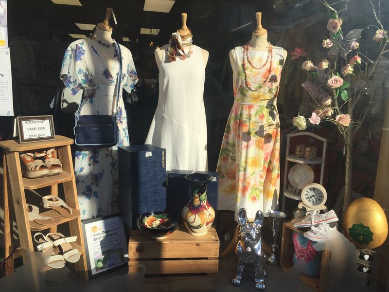 Rayleigh charity shop window with mannequins wearing clothes and bric a brac.