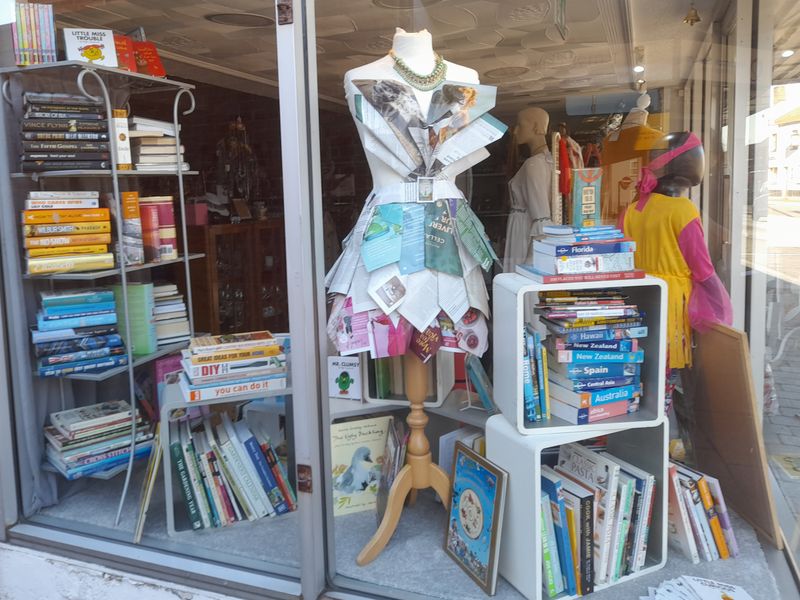 Attleborough charity shop window with a mannequin and lots of book displays