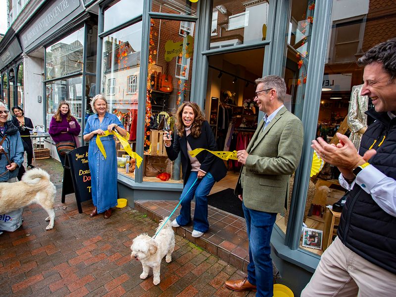 Outside Lewe's charity shop with charity staff photographed outside celebrating the opening of the shop, with Natasha Kaplinksy cutting the yellow ribbon