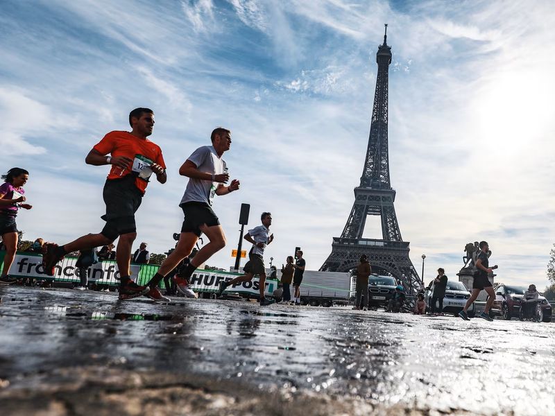 A load of runners running past the Eiffel Tower on a sunny day