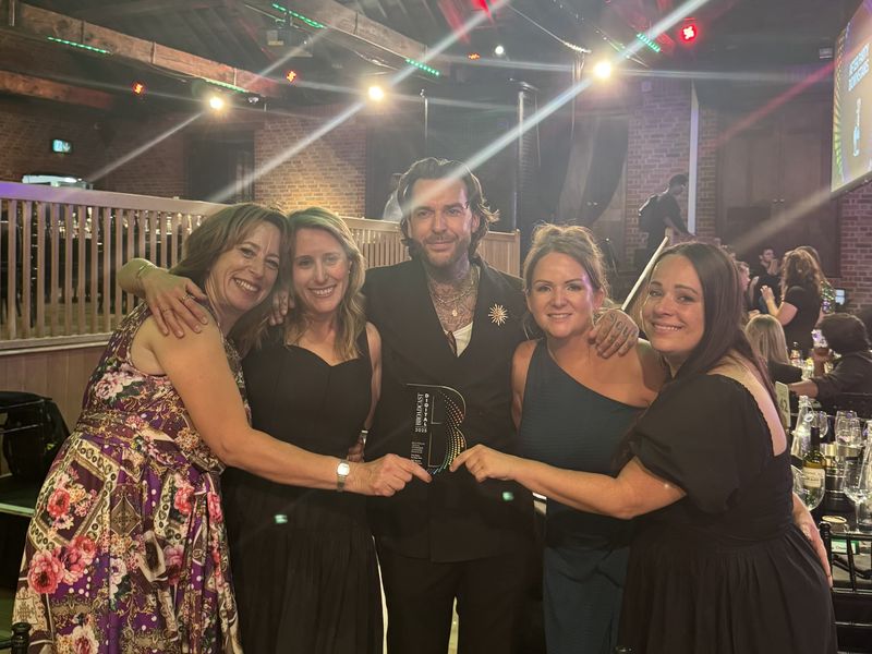Celebrity Pete Wicks pictured with four ladies from Dogs trust basildon staff, all holding up award and smiling