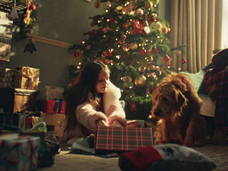 Daisy and her dog Buddy are cosy together under a Christmas tree